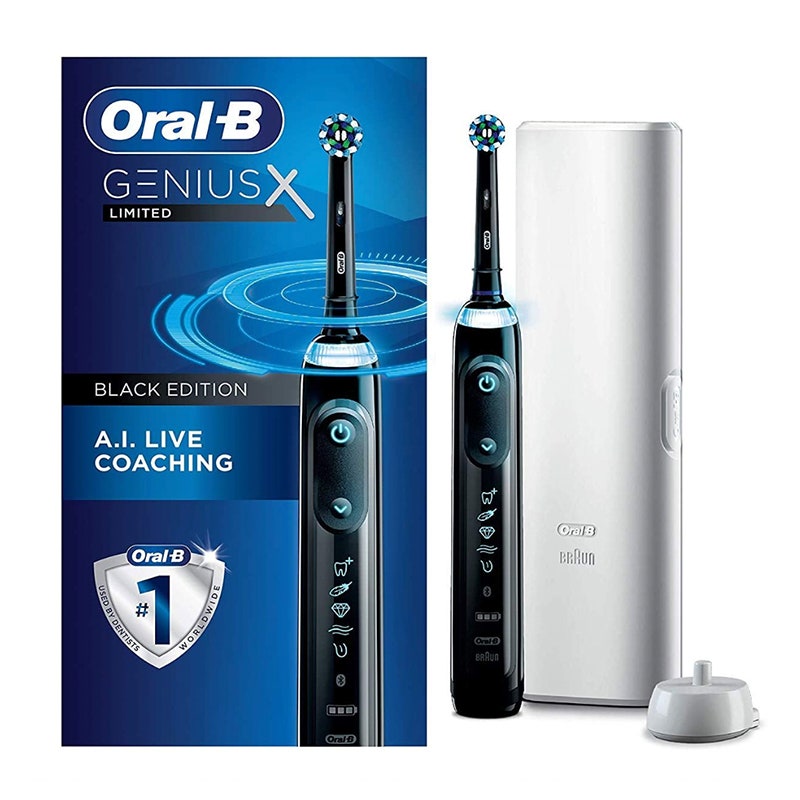 A black Oral-B Genius X electric toothbrush with white travel case and blue packaging box on a white background.